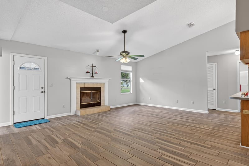 Living room with fireplace and wood-look flooring at 2164 Orangewood St, Middleburg, FL 32068