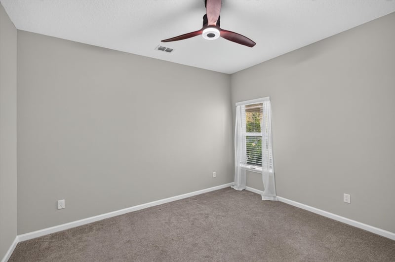 Carpeted bedroom with window and ceiling fan at 75875 Saffron Ln, Yulee, FL 32097