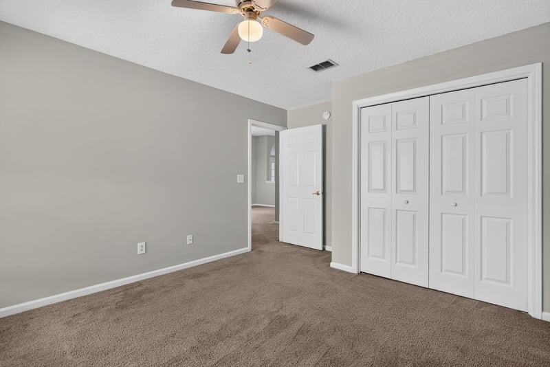 Empty carpeted room with closet doors at 11669 Collins Creek Dr, Jacksonville, FL 32258