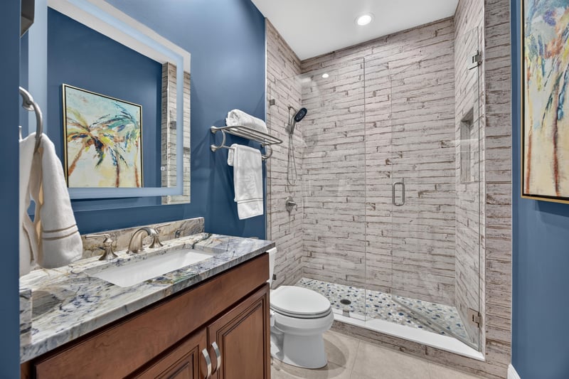 Bathroom with wood vanity and tile shower at 140 Ave De La Mer, Palm Coast, FL 32137