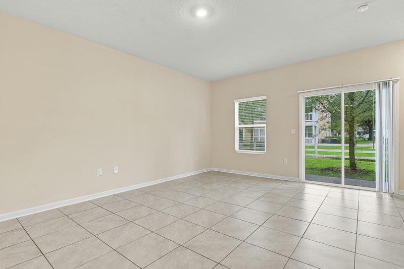 Empty living area with two windows and tile floor at 9555 Star Dr, Jacksonville, FL 32256