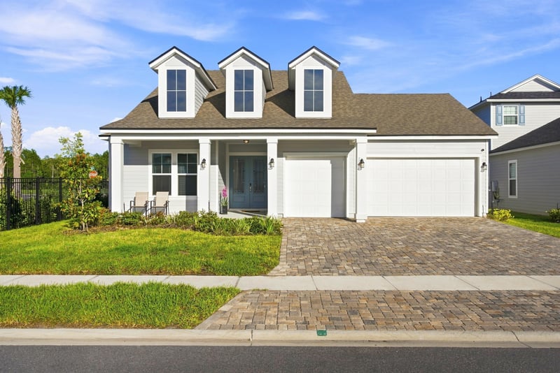 Front exterior in daylight with dormer windows and three-car garage at 27 Holly Rdg Wy, St. Augustine, FL