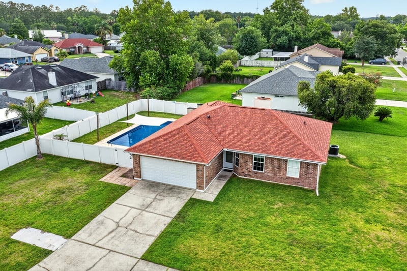 Aerial view of the home with pool along the street at 2164 Orangewood St, Middleburg, FL 32068