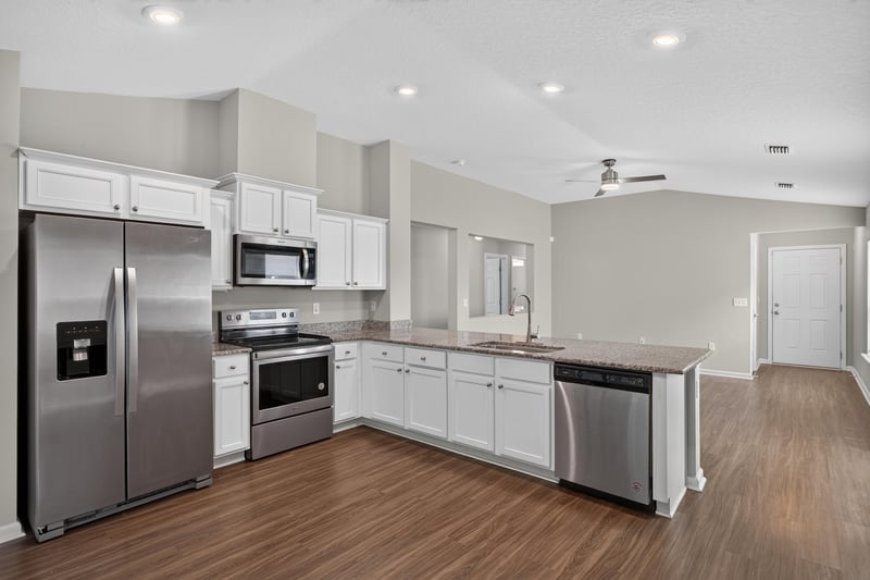 Kitchen with stainless appliances and white cabinets at 7118 Preston Pnes Trl, Jacksonville, FL