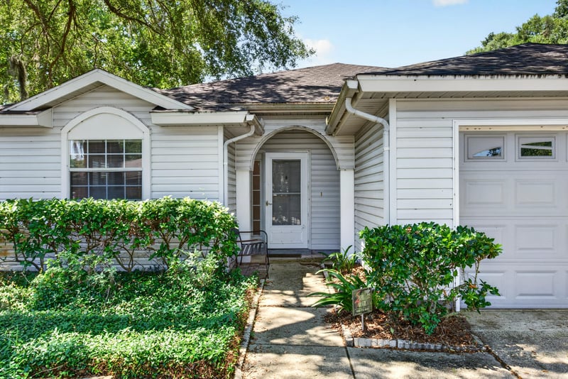 Covered entry with arched window and landscaping at 1108 Hidden Cove Cir S, Atlantic Beach, FL 32233