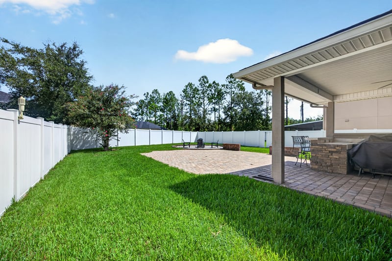Backyard lawn bordered by a white vinyl fence at 3660 Middlebrook Dr, Orange Park, FL 32065