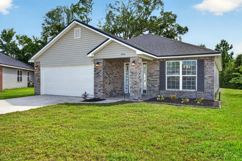 Front exterior with brick facade and wide driveway at 9846 Olivia St, Jacksonville, FL