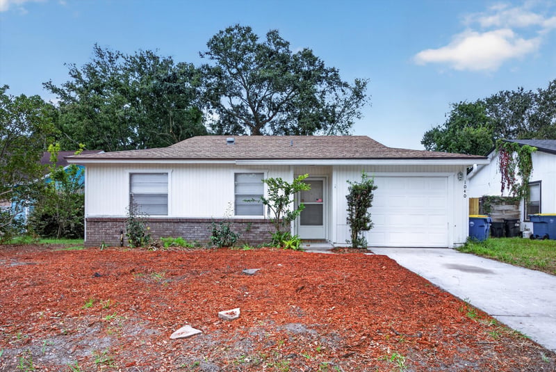 Front exterior along the driveway and landscaping at 1040 Willow Cove Ct E, Jacksonville, FL 32233
