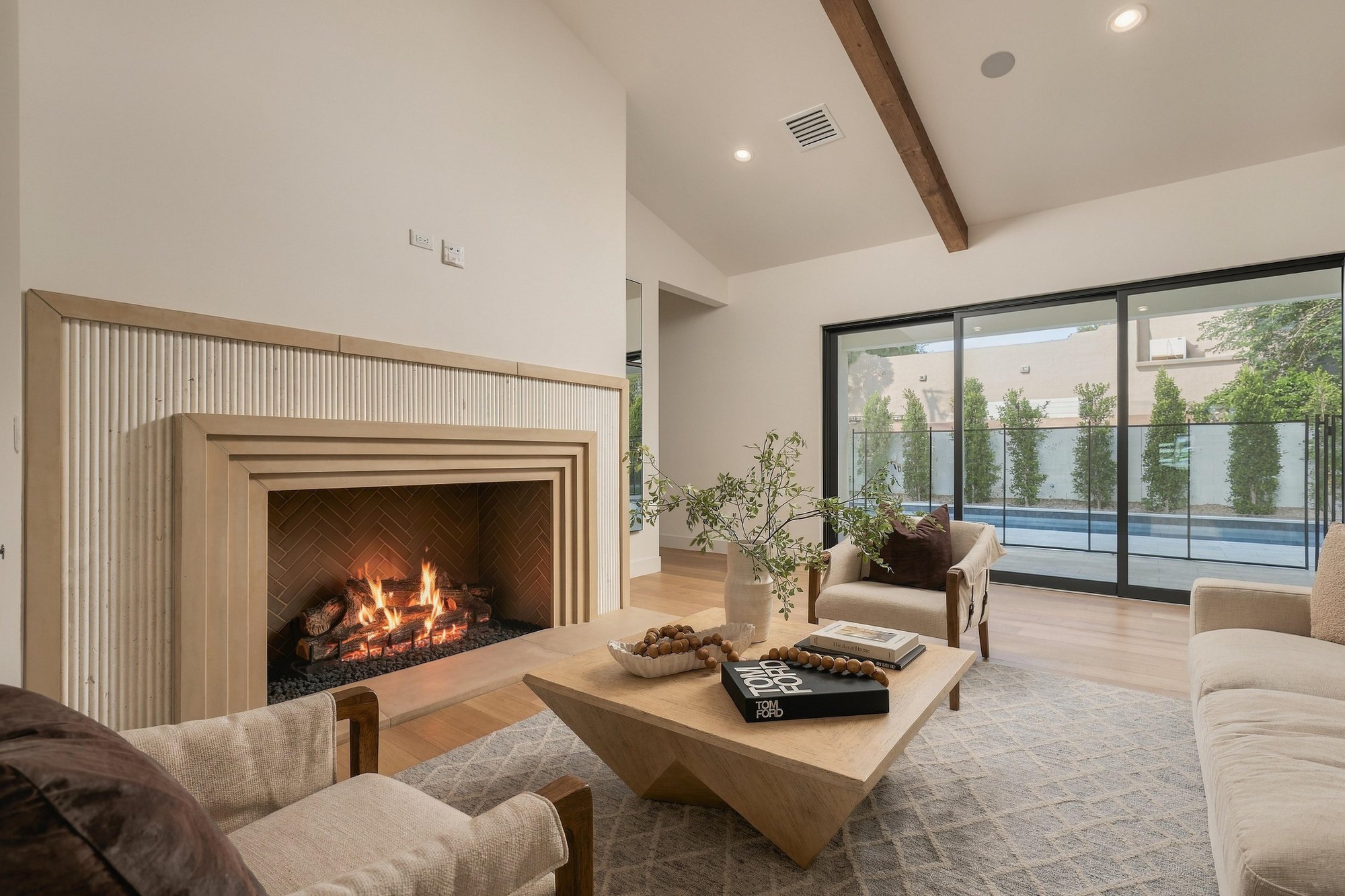 Living room with a stepped stone fireplace and sliding glass walls