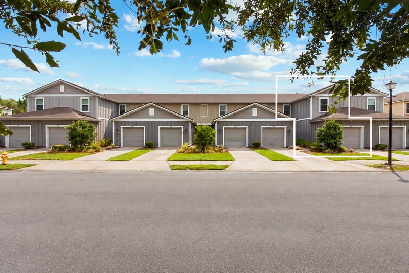 Front view with the home outlined among the row of townhomes at 9555 Star Dr, Jacksonville, FL 32256