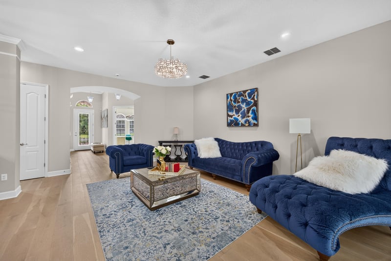 Living room with tufted blue sofas and chandelier at 276 Cross Ridge Dr, Ponte Vedra Beach, FL 32081