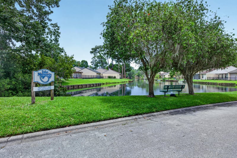 Community sign near pond and walking path in Jacksonville, FL