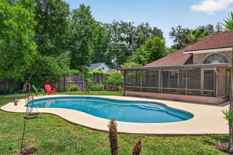 Backyard pool with red patio chair at 12810 Swamp Owl Ln