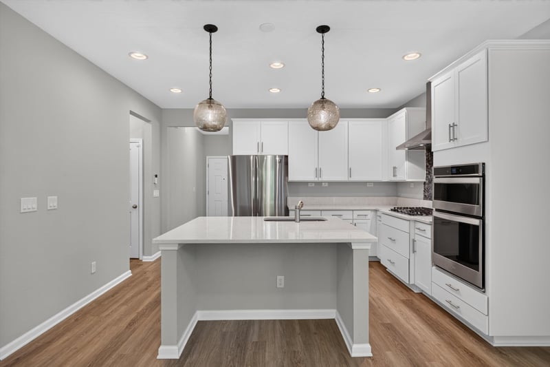 Kitchen island with quartz counters and pendant lights at 75875 Saffron Ln, Yulee, FL 32097