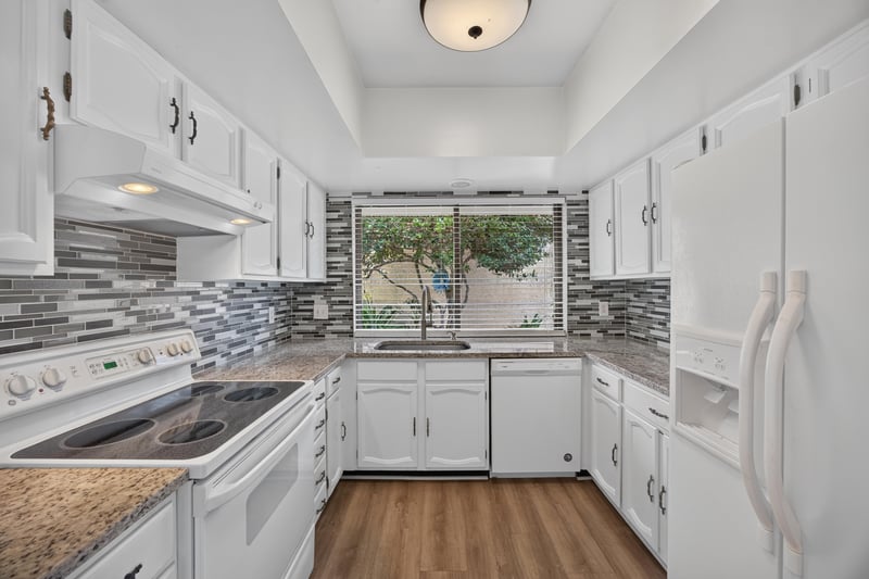 Kitchen with white appliances and granite counters at 3407 Fairbanks Grant Rd N, Jacksonville, FL 32223