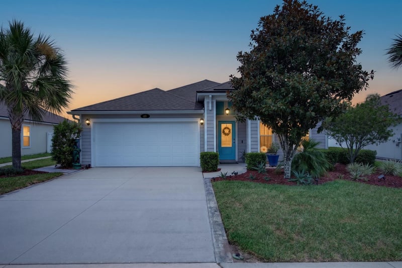 Front exterior at day-to-dusk showing teal front door at 85 Amia Dr, St. Augustine, FL 32086