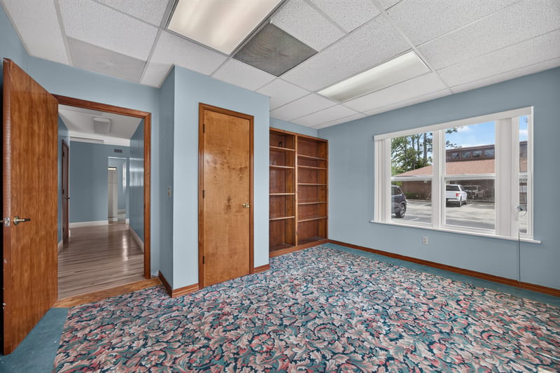 Doorway with built-in wood shelving and floral carpet at 1543 Kingsley Ave #19, Orange Park, FL 32073