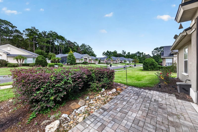 Backyard with paver walkway and landscaping at 2131 E Stone Creek Dr, Fleming Island, FL