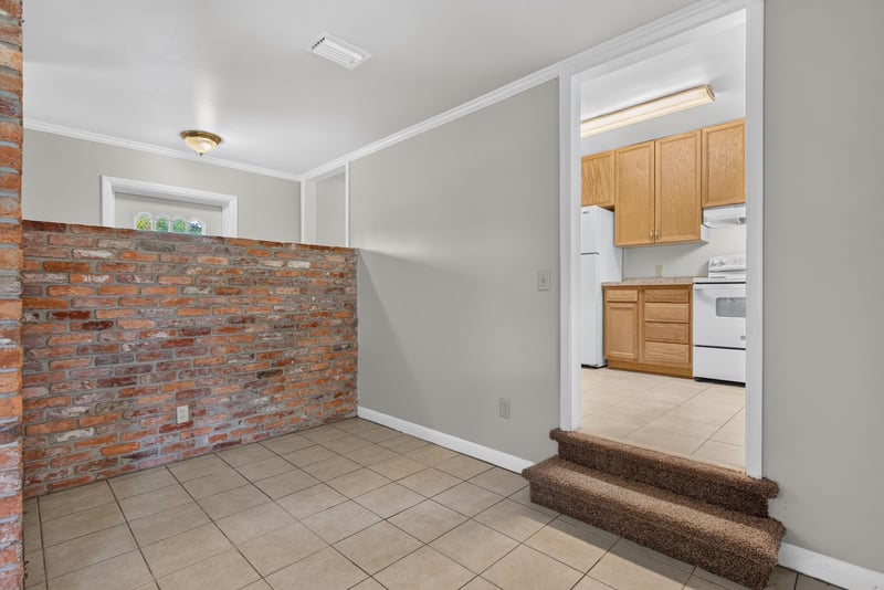 Living room opening to kitchen past brick half-wall at 2618 Arlex Dr E, Jacksonville, FL