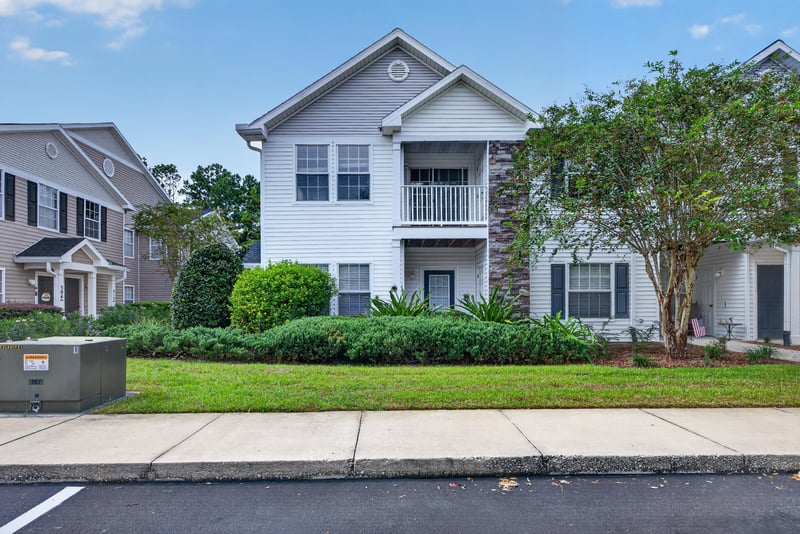 Front exterior of the condo building with lawn at 575 Oakleaf Plantation Pkwy, Orange Park, FL 32065