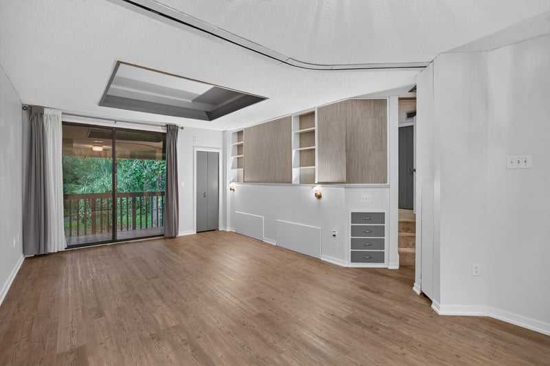Living room with built-in shelving and sliding glass door at 2910 Ravines Rd, Middleburg, FL 32068
