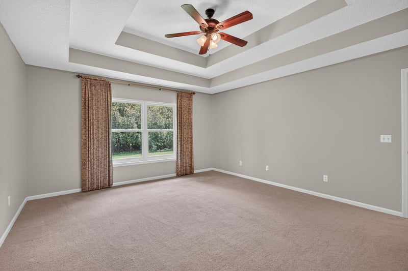 Empty bedroom with tray ceiling and curtains at 1955 GUARDED Way, Fleming Island, FL 32003