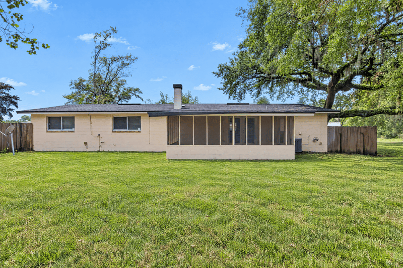 Rear exterior with screened porch and open lawn at 1435 Undine Ave, Jacksonville, FL
