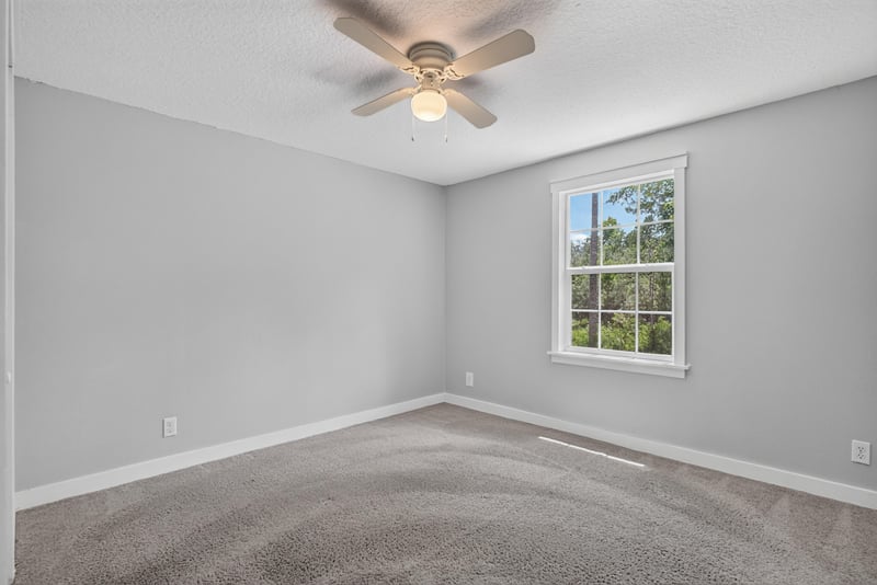 Bedroom with carpet, window, and ceiling fan at 4890 McAllister Rd, Middleburg, FL 32068
