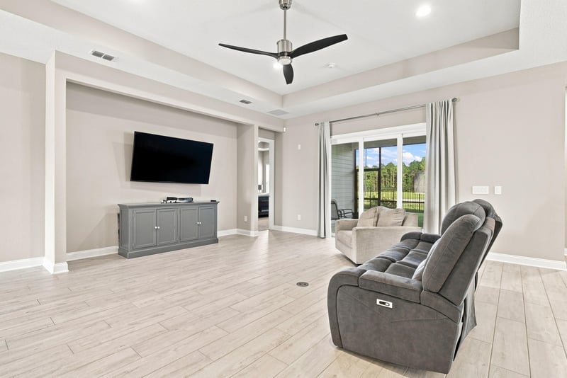 Living room with mounted TV and tray ceiling at 27 Holly Rdg Wy, St. Augustine, FL