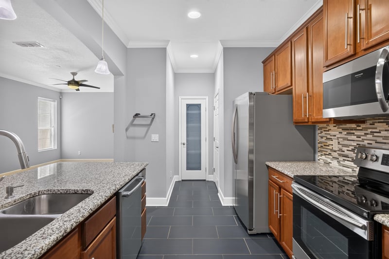 Kitchen sink area with granite counters and tile floor at 6217 Eclipse Cir, Jacksonville, FL 32258