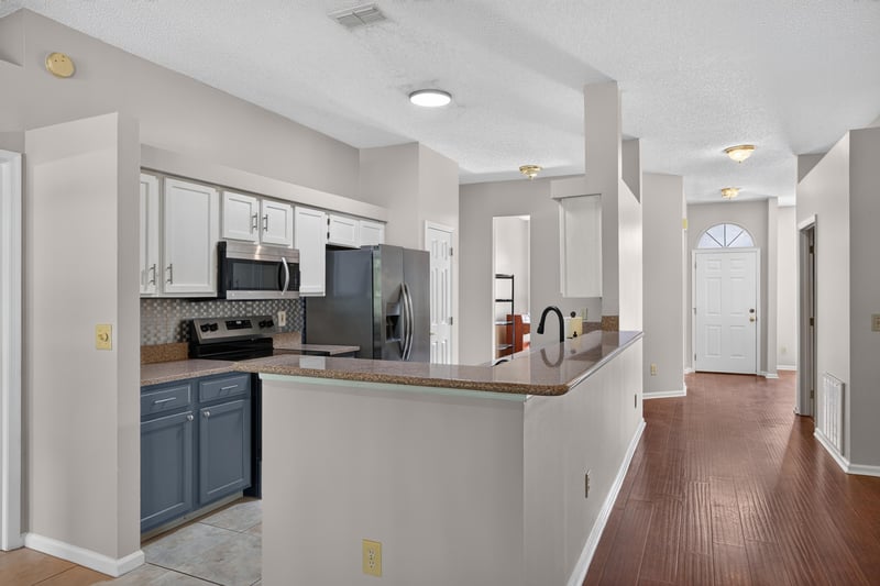 Kitchen with white cabinets and hallway view at 11828 Heather Grove Ln, Jacksonville, FL