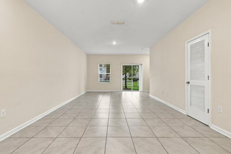 Open living space with tile floors leading to windows at 9555 Star Dr, Jacksonville, FL 32256