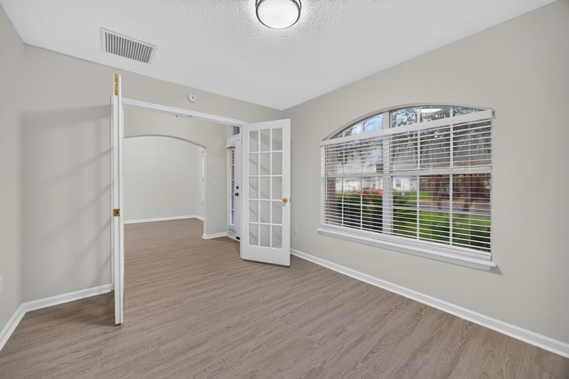 Empty room with French doors and arched window at 706 Bonaparte Dr, Jacksonville, FL 32218
