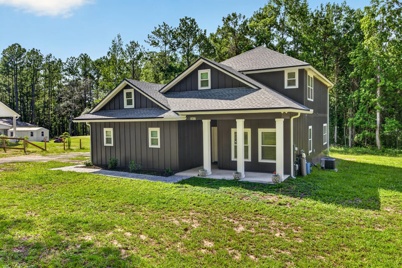 Front exterior wide view with mature trees and grass yard at 2817 Camel Cir, Middleburg, FL