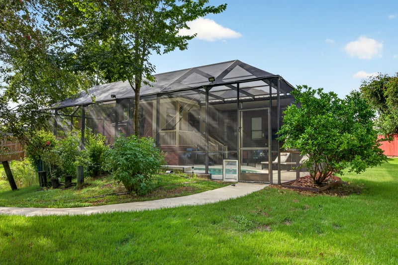 Screened lanai exterior with garden path at 2125 Blue Heron Cove Dr, Orange Park, FL 32003