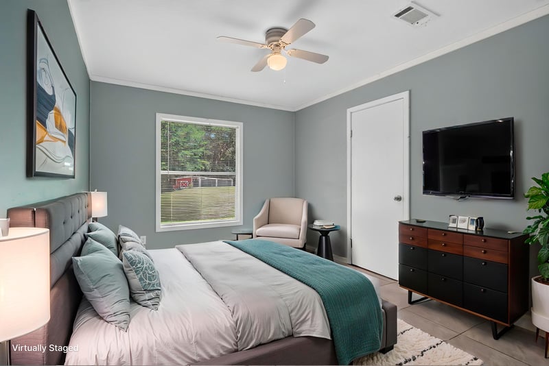 Bedroom staged with bed and TV stand at 2549 Snapdragon Ave, Middleburg, FL 32068