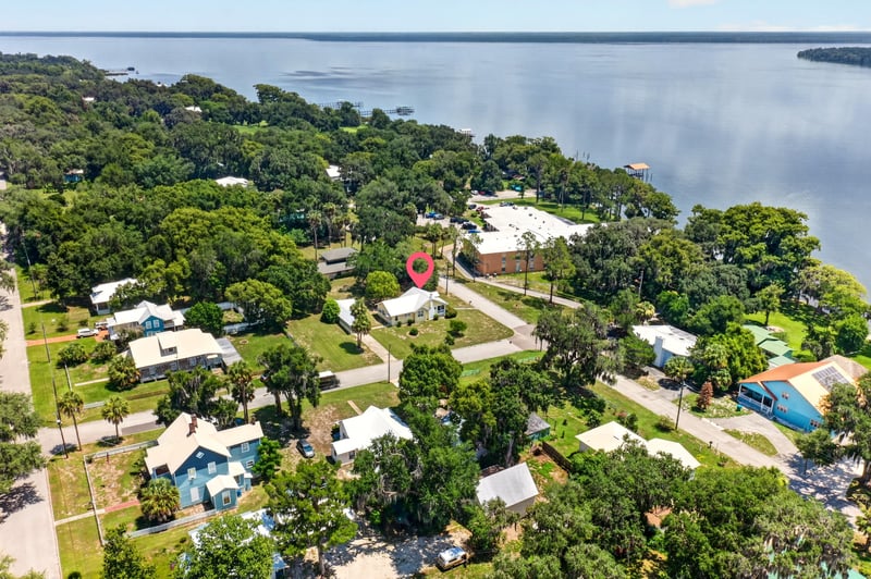 Drone neighborhood view with lake in the distance in Crescent City, FL