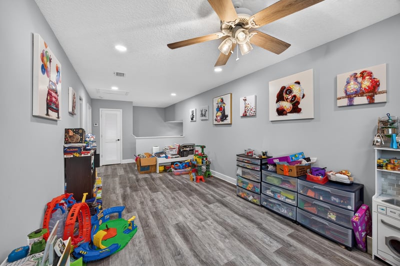 Playroom with toy shelves and wood-look flooring at 2817 Camel Cir, Middleburg, FL