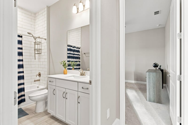 Bathroom with dual sinks and subway tile shower at 27 Holly Rdg Wy, St. Augustine, FL