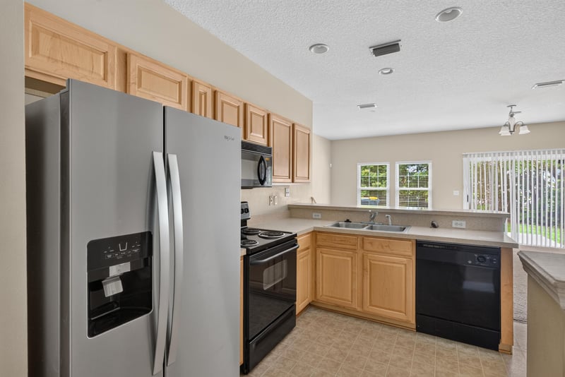 Kitchen with stainless refrigerator and window at 12359 Mangrove Forest Ct, Jacksonville, FL 32218