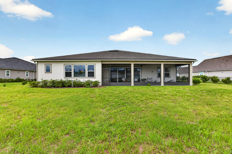 Backyard lawn with screened porch at 85491 Fall River Pkwy, Fernandina Beach, FL 32034