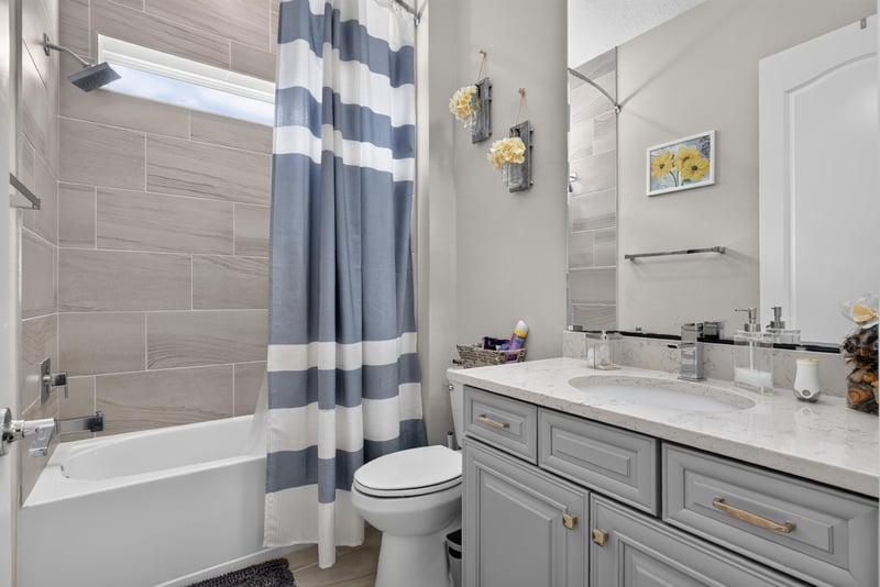 Bathroom with tub and striped shower curtain at 22 Azura Point