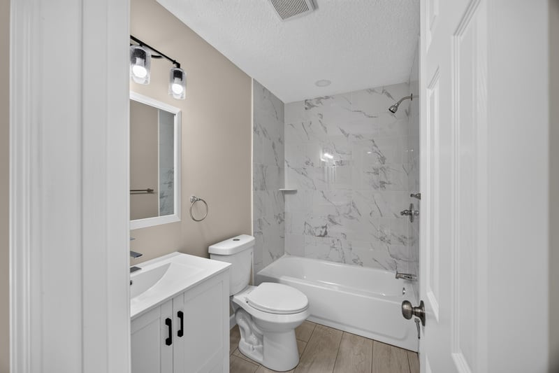 Bathroom tub and shower with marble surround at 4117 Wilcrest Ct, Jacksonville, FL 32277