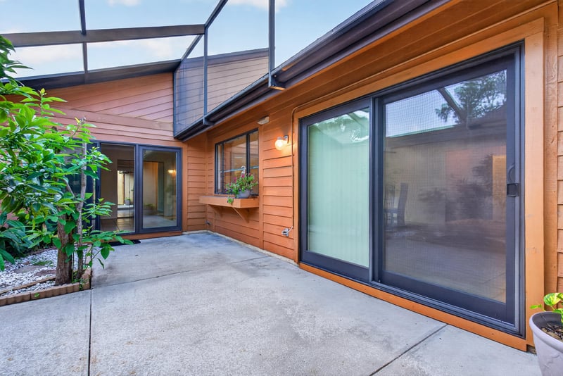 Rear patio with sliding glass doors and wood siding at 3515 Cormorant Branch Ct, Jacksonville, FL