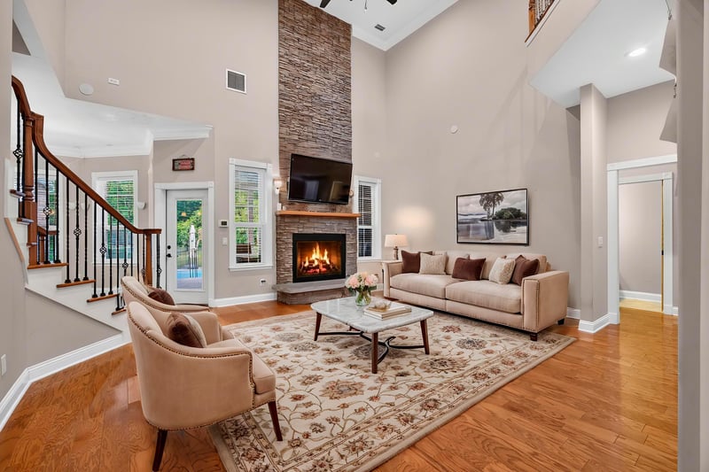Two-story great room staged with sofa and stone fireplace at 1735 Hagans Ridge Ct
