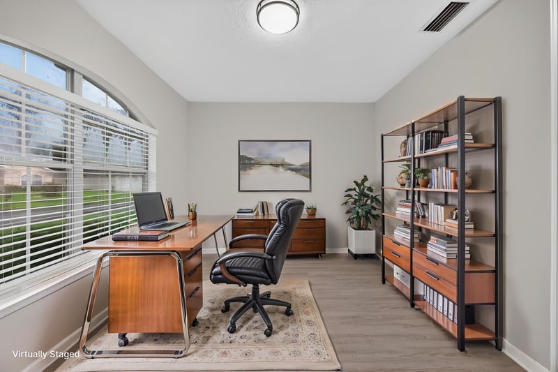 Virtually staged home office with desk and bookshelf at 706 Bonaparte Dr, Jacksonville, FL 32218