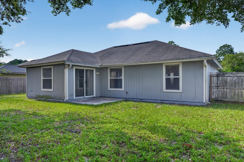 Backyard with fence and gray siding at 8519 Blazing Star Ct, Jacksonville, FL 32210