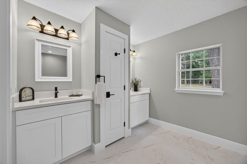 Bathroom vanity with mirror and door at 1161 Whispering Pines Rd, Jacksonville, FL 32259