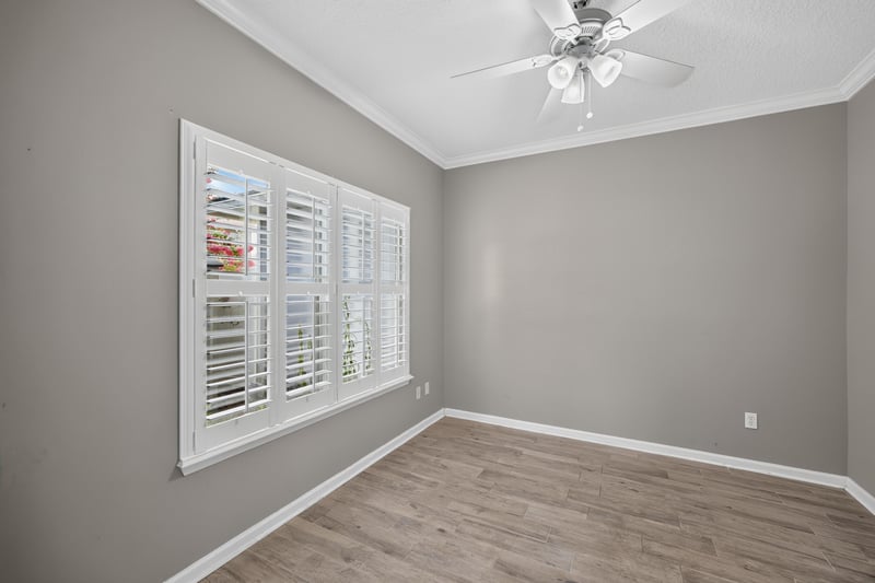 Empty room with wood-look floors and shuttered windows at 1493 Greyfield Dr, St. Augustine, FL 32092