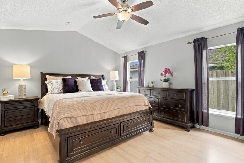 Primary bedroom with dark wood furniture and ceiling fan at 11197 Illford Dr